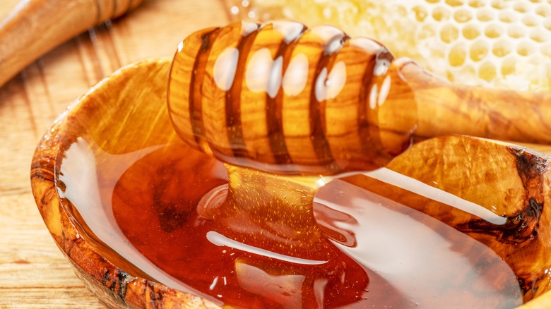 honey and scooper with wooden bowl