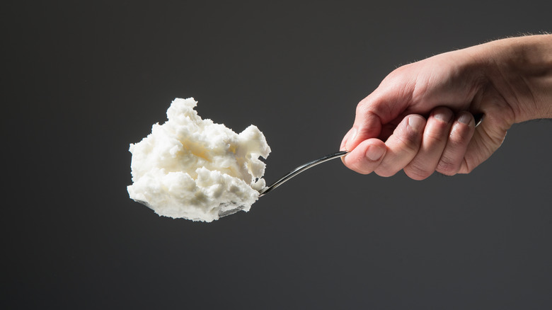 person holding spoonful of lard