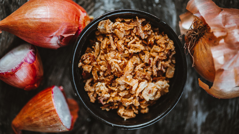 Crispy onions in bowl and whole onions