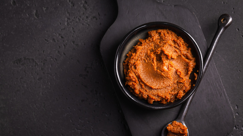 Miso paste in black bowl with black spoon