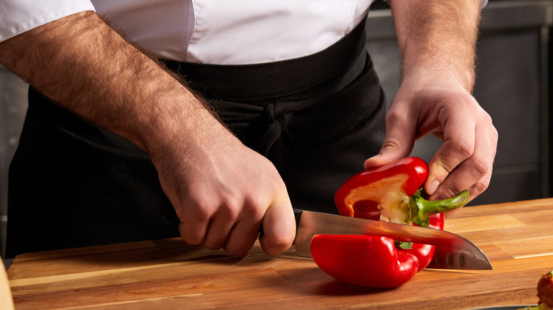 Person chopping red bell pepper