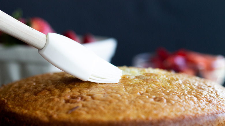 applying simple syrup to cake