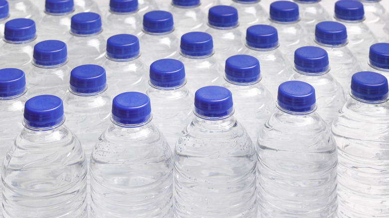 Rows of still water bottles with blue caps