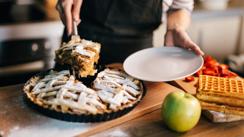 person slicing apple pie