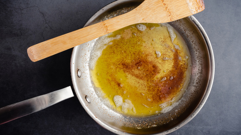 Brown butter in stainless steel pan with wooden spoon