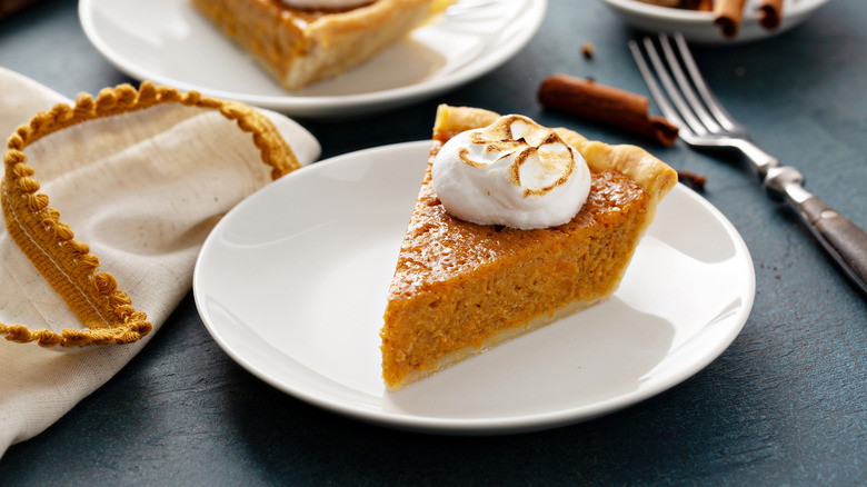 Slice of sweet potato pie with marshmallow topping on white plate