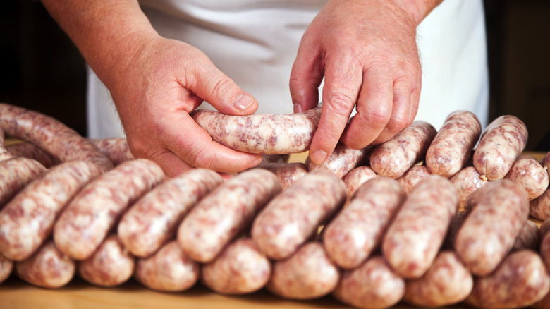 butcher holding freshly-made sausage