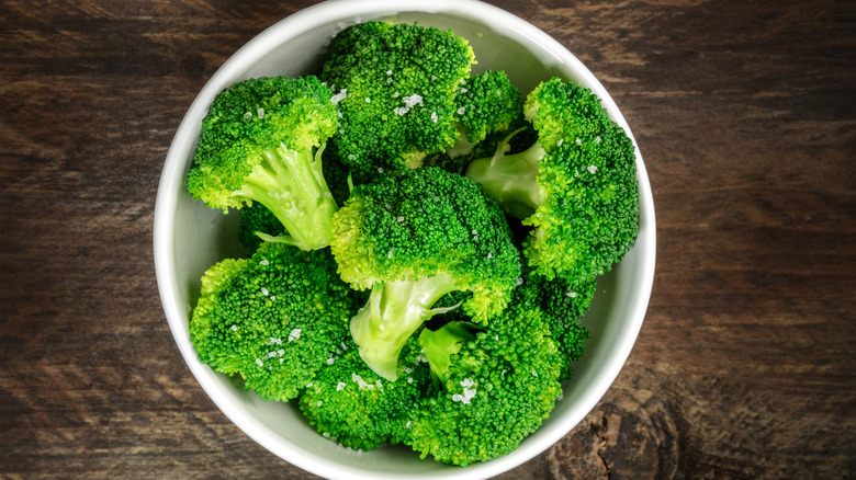 Bowl of cooked broccoli sprinkled with sea salt