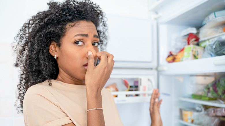 Woman smelling expired food