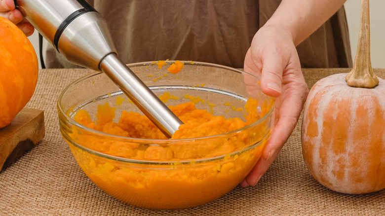 person making pumpkin puree