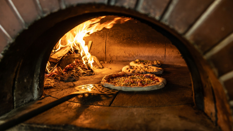 Several pizzas cooking in pizza oven