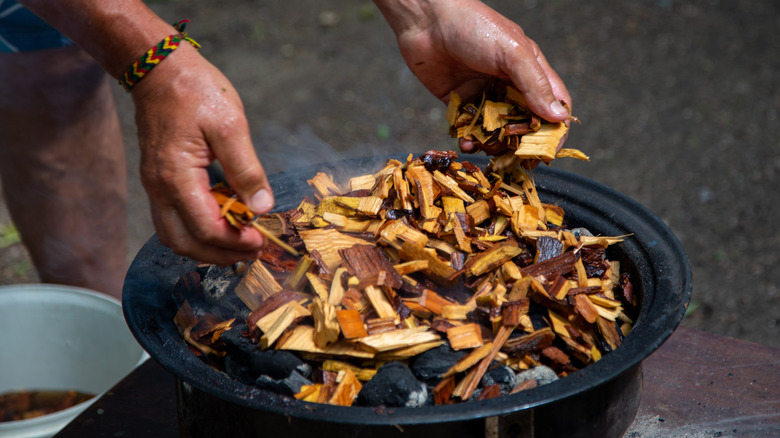 adding wood chips to smoker