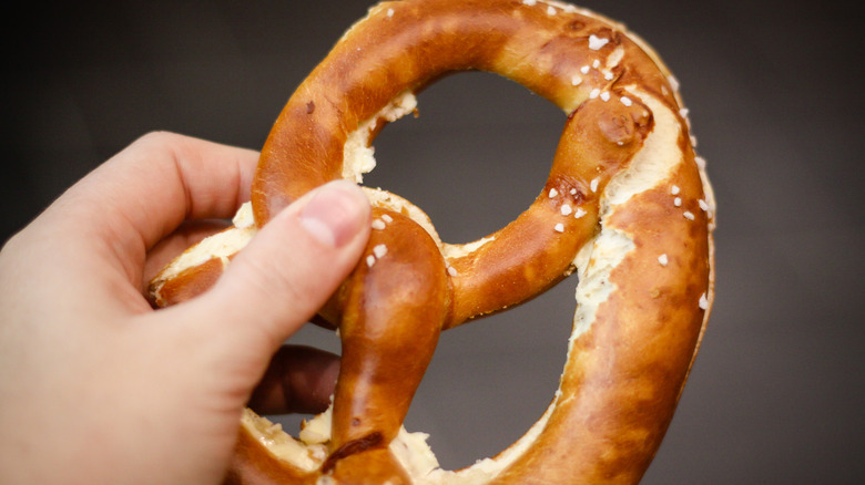 Person holding baked pretzel