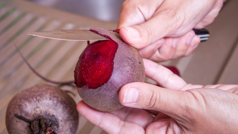 Person peeling beets with knife