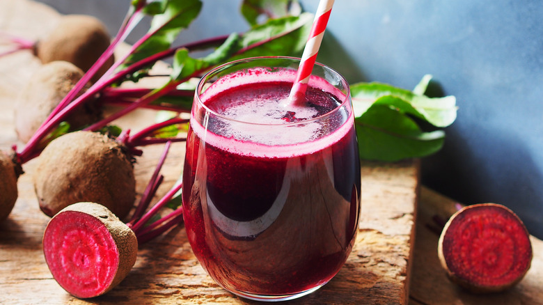 Beet juice in glass with beets