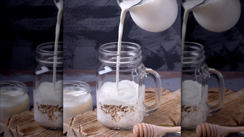 Pouring milk into mason jar with oats