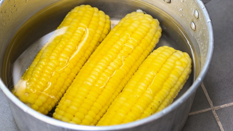 cooked corn soaking in water