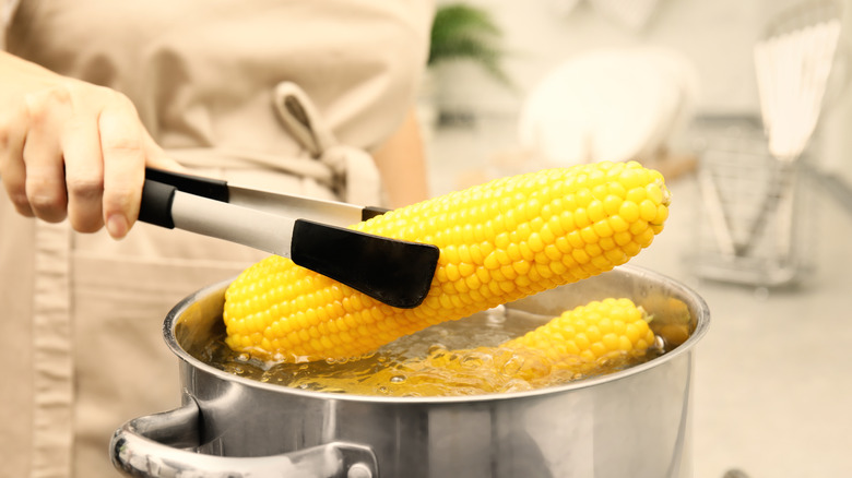 woman in apron boiling corn