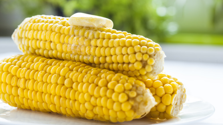 three corn cobs with butter