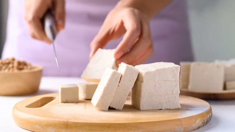 person cutting tofu