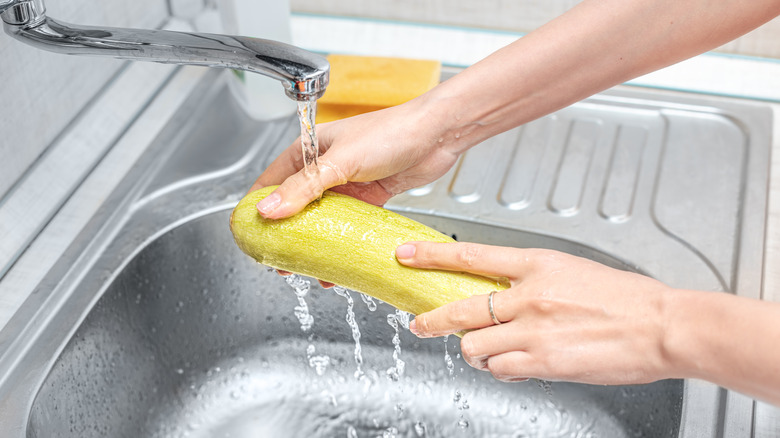 washing squash under running water