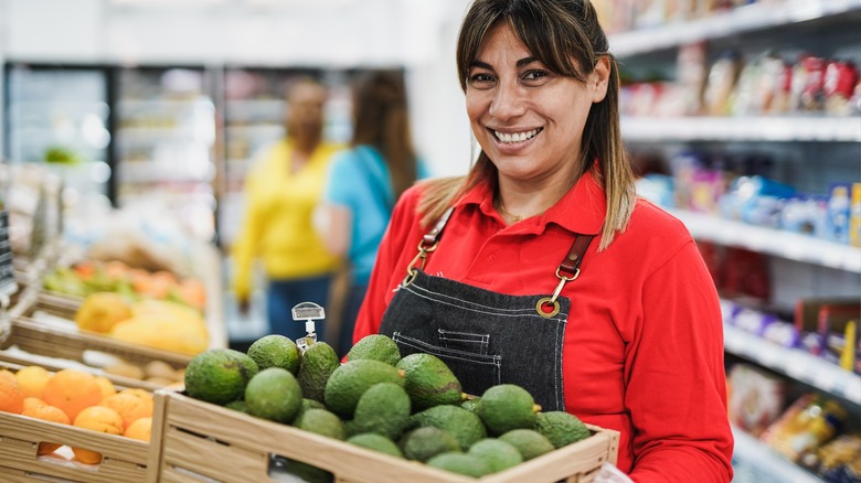 woman holding avocados in supermarket