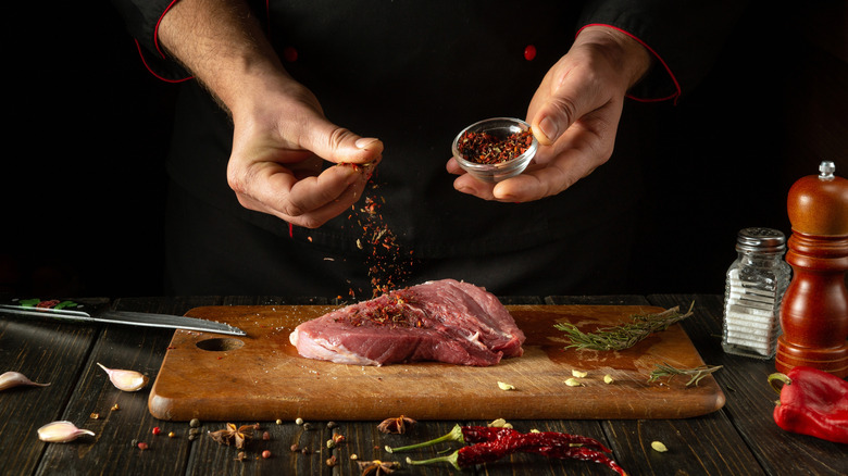 Chef preparing raw steak