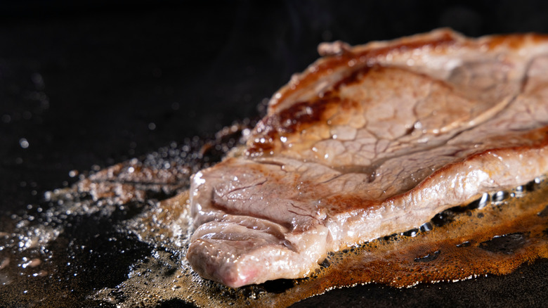 Steak cooking on griddle