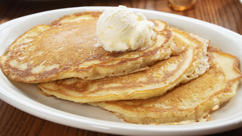 Three pancakes with butter scoop