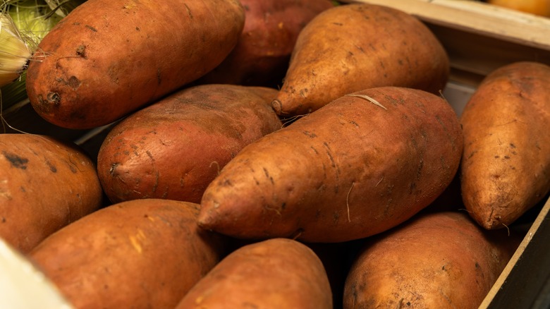 Some orange sweet potatoes on a baking sheet