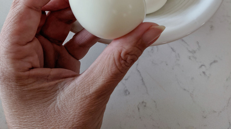 person holding hard-boiled egg