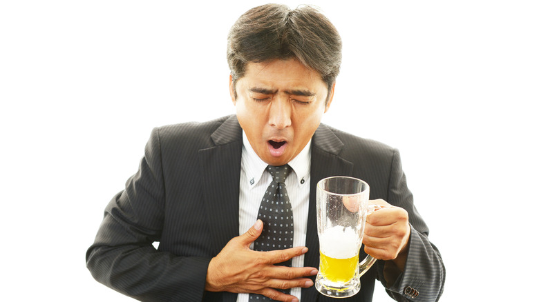 Man drinking beer with nausea