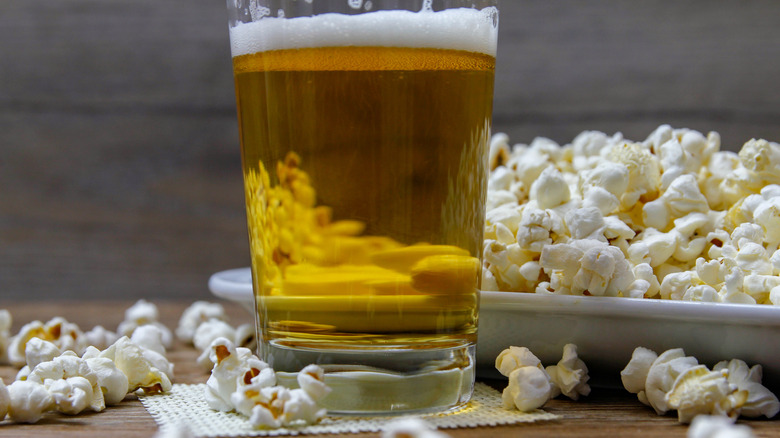 Beer and popcorn on table