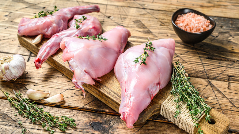 raw rabbit legs on wooden board