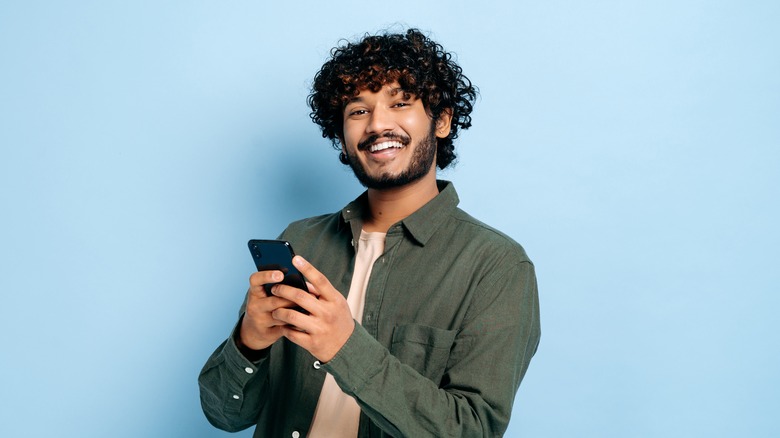 Man holding phone and smiling