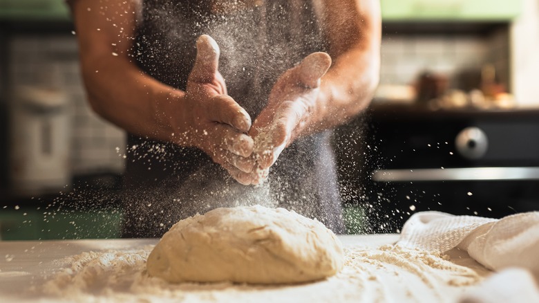 person kneading dough