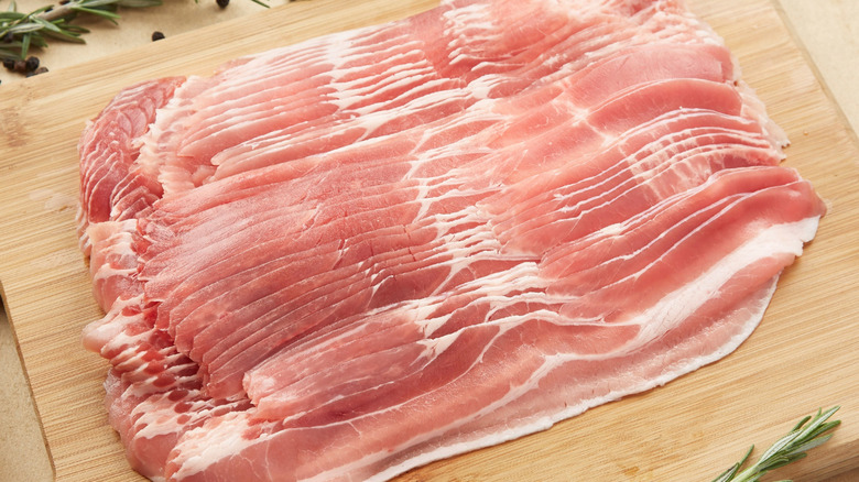 Slices of bacon on wooden board