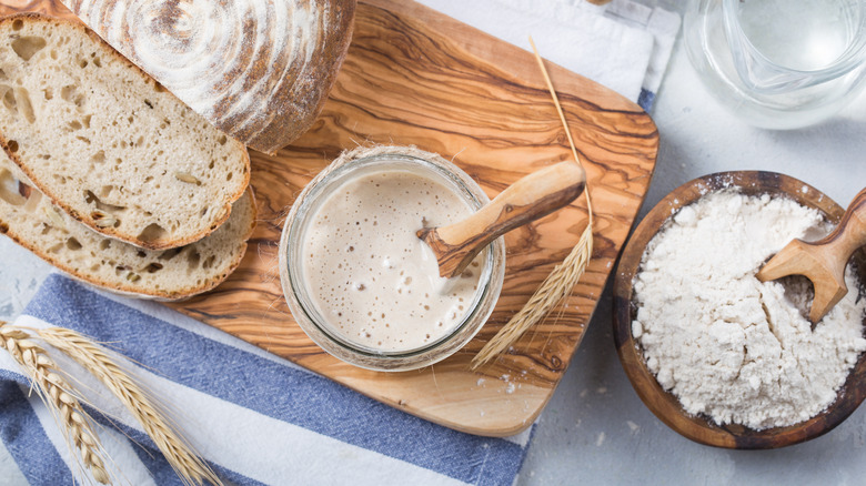 jar of activated yeast on chopping board bread flour