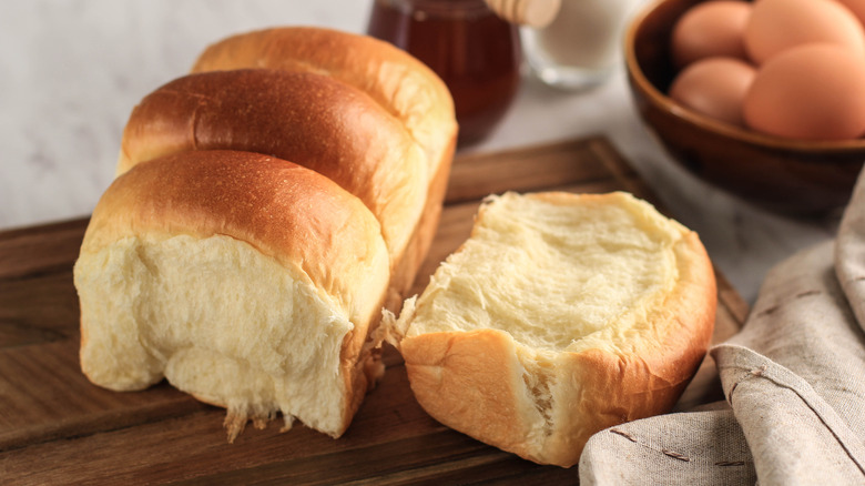 fluffy bread cut open on wooden chopping board