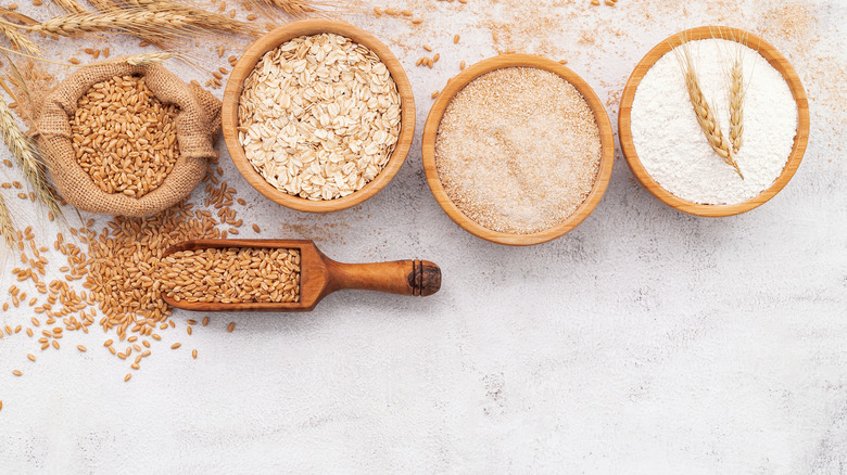 different flours in wooden bowls white floor