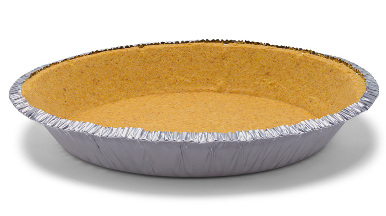 Pie crust in foil tin against a white background