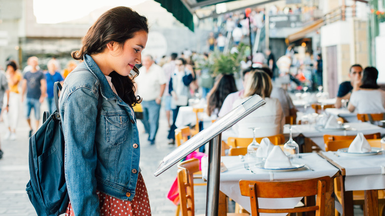 woman looking at restaurant menu 