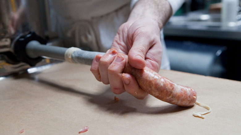 person making sausages by hand