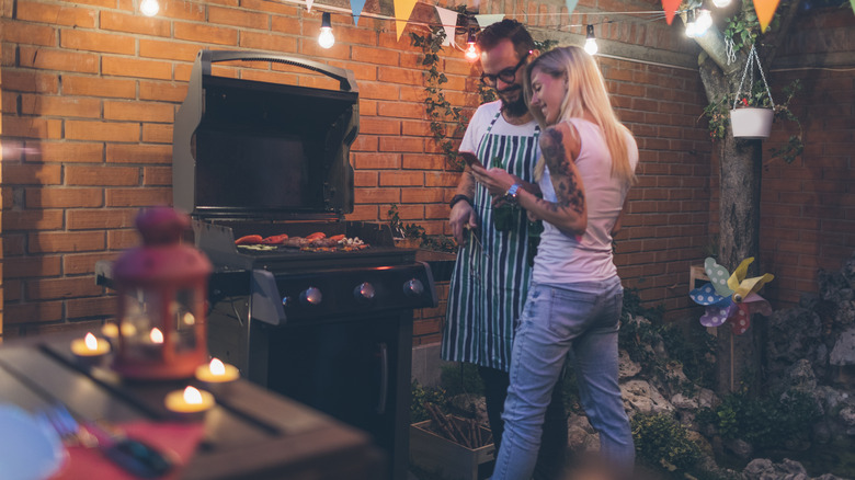 Couple on phone at barbecue