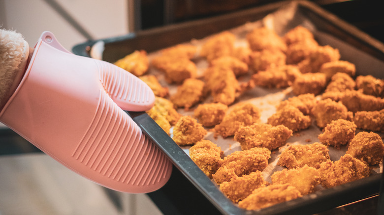 chicken nuggets being placed in oven