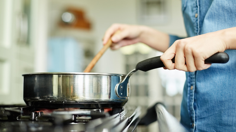 woman holding pan on stove