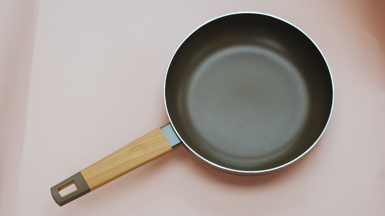 empty frying pan on pink background