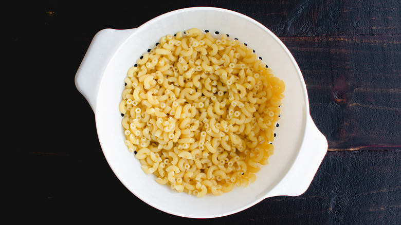 drained macaroni in plastic strainer