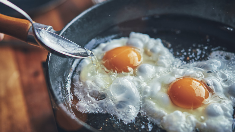 basting two eggs in pan