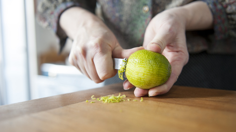 person zesting lime